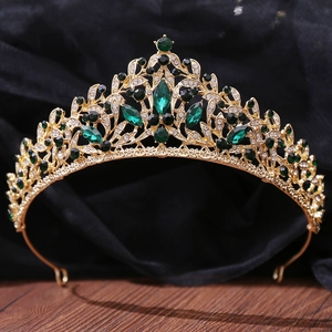 Macro detail of vintage gold crown with green gems and white crystal rhinestones