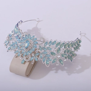 Détail d'une couronne de mariée en cristal avec pierre bleue en poire et motifs de feuilles argent
