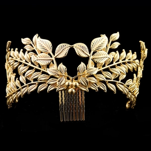 Close-up of golden leaf hair comb showing intricate vein textures on a black background