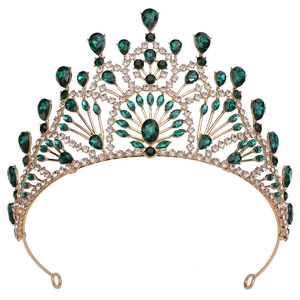 Macro detail of Baroque gold crown with emerald green gems and white crystal accents