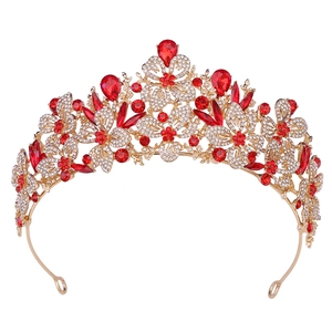 Detailed view of luxury gold leaf crown with red crystal teardrops and white rhinestones