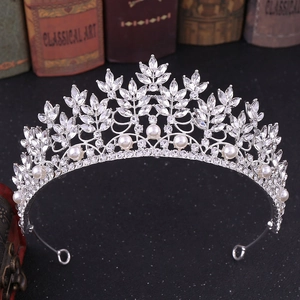 Detailed shot of silver bridal tiara featuring leaf rhinestones and white pearls