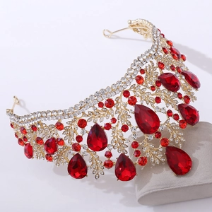 Macro shot of gold baroque crown with large red teardrop crystals and white rhinestones