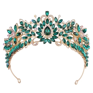 Détail de couronne dorée avec pierres précieuses vert émeraude et strass scintillants AB