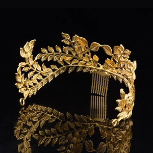 Detailed macro view of golden laurel leaf bridal headpiece with elegant metal hair comb