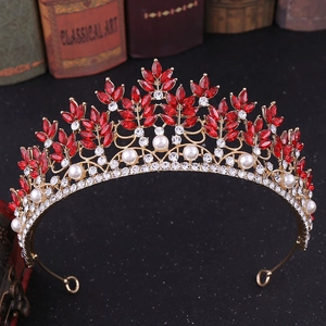 Detail of baroque crown with red marquise rhinestones and white pearls on antique book