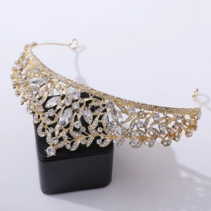 Close-up of golden bridal tiara with intricate leaf design and shimmering rhinestones