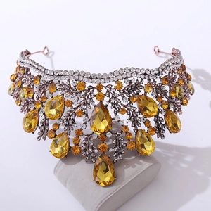 Close-up of amber teardrop crystals and vintage bronze leaf textures on a royal crown