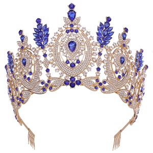 Luxury Baroque gold pageant crown with blue gemstones and white rhinestones on white background