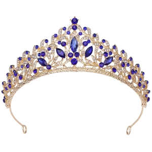 Elegant gold alloy crown with royal blue gemstones and white rhinestones on white background