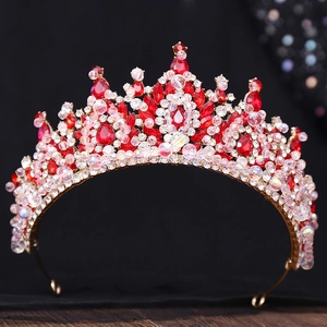 Détail d'une couronne baroque dorée avec grands cristaux rouges et perles artisanales