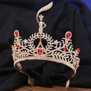Close-up of golden pageant crown with red teardrop gems and white rhinestones
