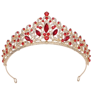 Detail of European gold bridal crown with intricate hollow carving and red rhinestones