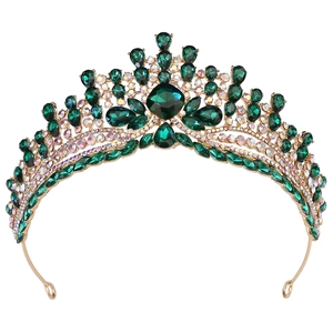 Détail de la couronne baroque dorée sertie de pierres vertes foncées et de strass brillants