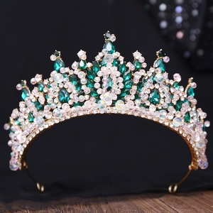 Détail d'un diadème baroque doré orné de pierres vert foncé et de strass étincelants