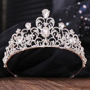Elegant silver bridal crown with leaf rhinestones and pear-shaped crystals on dark wood