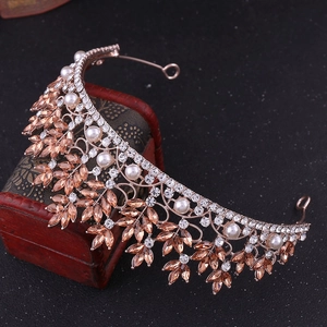 Close-up of rose gold bridal crown with marquise crystals and pearls on a vintage box