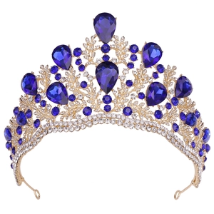 Detailed macro view of the gold crown featuring royal blue teardrop crystals and floral designs