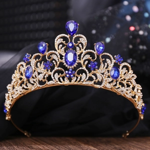 Close-up of golden crown featuring deep blue teardrop rhinestones and intricate metalwork