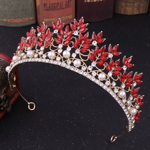 Close-up of baroque crown with red crystals and pearls on vintage book background
