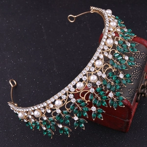 Elegant Baroque bridal crown with emerald crystals and pearls on a vintage wood box