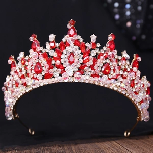 Couronne de mariée de luxe dorée avec pierres précieuses rouges et cristaux sur fond noir