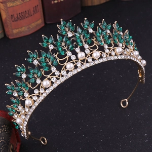 Detailed macro view of golden baroque bridal crown with green leaf-shaped gemstones and pearls