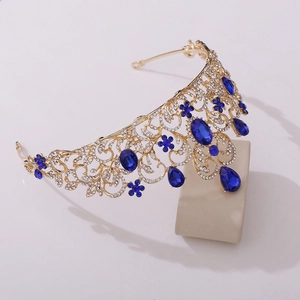 Detail of a vintage golden bridal crown with blue gemstones and sparkling rhinestones