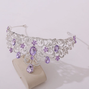 Detail of silver bridal crown with purple crystals and intricate hollow scroll patterns