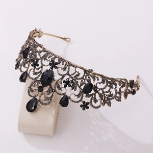 Close-up of vintage bronze bridal crown with intricate floral filigree and black crystals