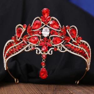 Macro shot of gold tiara with red teardrop stones and heart-shaped crystals on dark silk