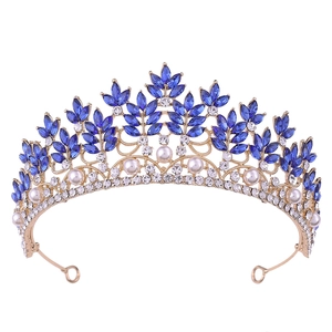 Macro detail of Baroque bridal crown with deep blue crystals and white pearls on gold base