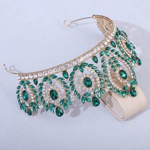 Macro view of gold alloy crown showing emerald green gemstones and intricate crystal inlay
