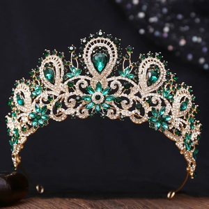 Close-up of gold bridal crown with deep green teardrop gemstones and white rhinestones