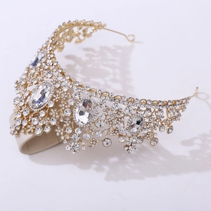 Close-up of golden bridal tiara with floral patterns and large crystal centerpieces