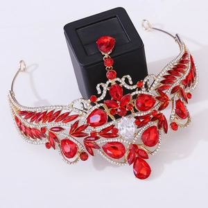 Detail of golden Baroque bridal crown with red teardrop rhinestones and ruby heart accents