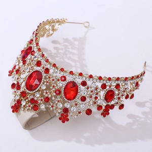 Detail of vintage crown with gold metal base and large red oval rubies on white background