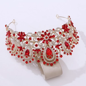 Detail of luxury gold bridal crown with red pear-shaped rhinestones and floral metalwork