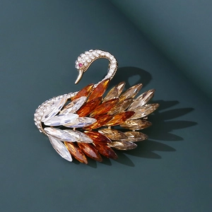 Elegante broche de cisne con cristales ámbar y pedrería blanca sobre fondo oscuro