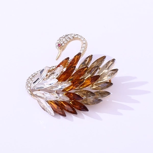 Close-up of golden swan brooch with sparkling marquise-cut crystals and white rhinestones