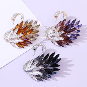 Elegant swan crystal brooches in amber, purple, and smoky grey with sparkling rhinestones