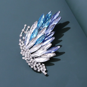 Close-up of elegant blue crystal wing brooch with silver finish and sparkling rhinestones