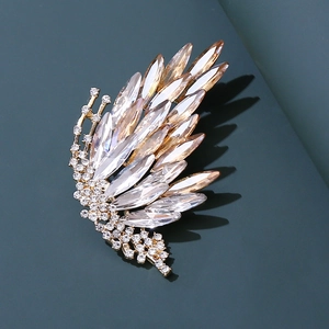 Elegant gold butterfly wing brooch with gradient champagne crystals on a dark background