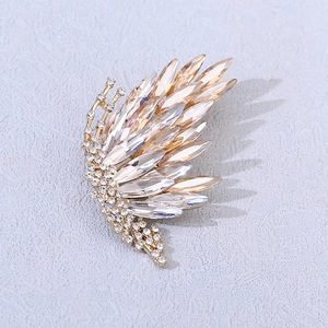 Detailed close-up of butterfly wing brooch with gradient champagne crystals and gold plating