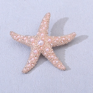 Vue macro détaillée de la broche étoile de mer en or rose avec incrustation de perles et métal