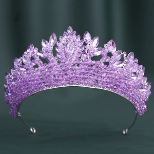 Gros plan des cristaux violets et des strass marquises sur la base d'une couronne argentée