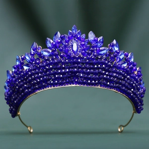 Détail macro d'une couronne en cristal bleu roi avec base en métal doré sur velours