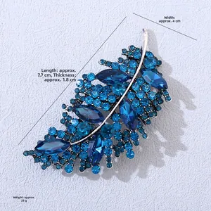 Vista dettagliata della spilla a foglia argento con strass blu e misure 7,7x4cm