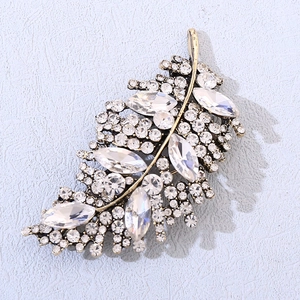 Vista dettagliata della spilla a forma di foglia con strass e cristalli marquise