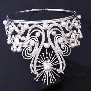 Detail showing elaborate silver tiara with white pearls and rhinestones on black background